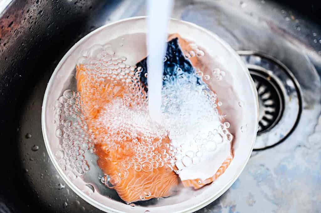 washing salmon in running water