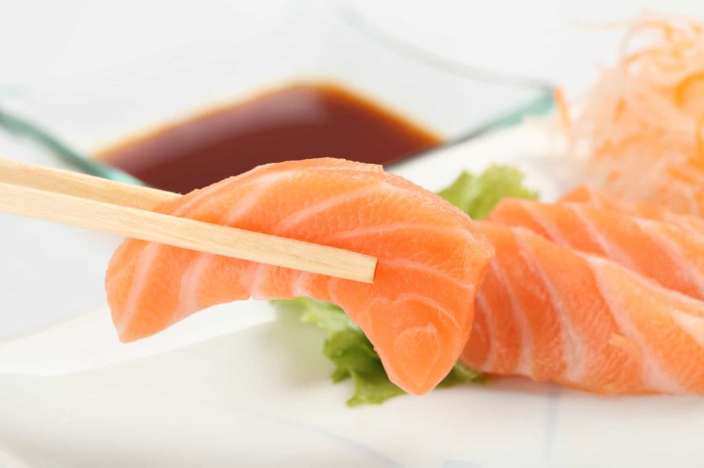 picking salmon sashimi using chopsticks