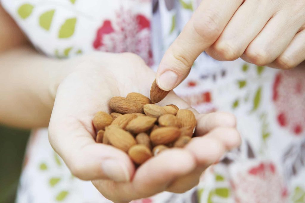woman eating a handful of almonds