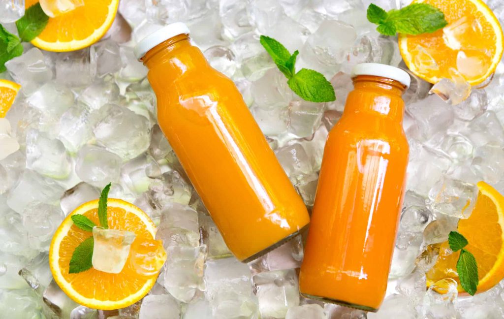 two bottles of orange juice on ice