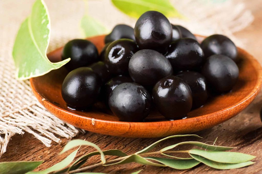 black olives in a wooden plate