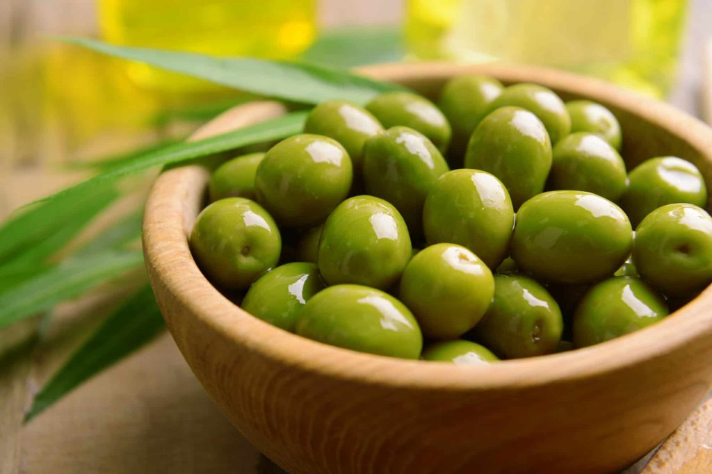 green olives in a brown bowl 