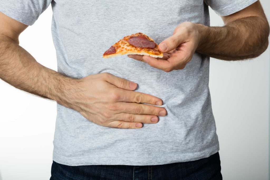 man rubbing his stomach, got poisoned of frozen pizza