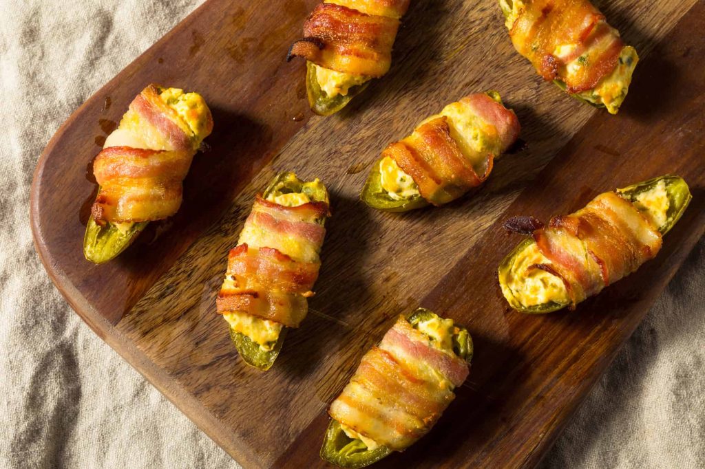 homemade bacon wrapped jalapeno poppers on a cutting board