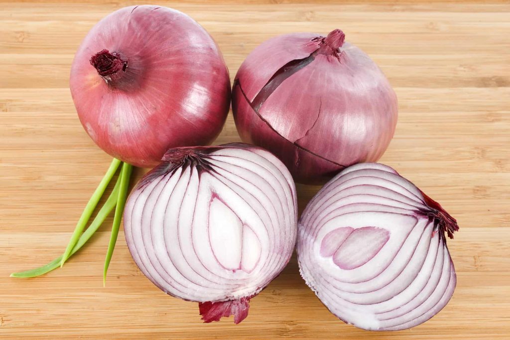 red onion on a wooden cutting board