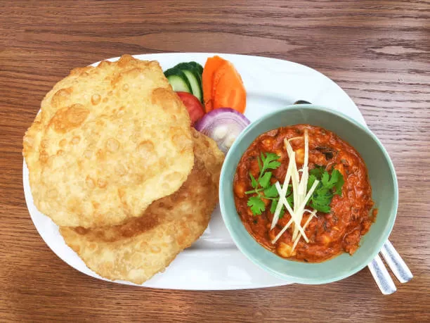 Chole bhature, a spicy chickpea curry served beside puffed deep-fried bread.