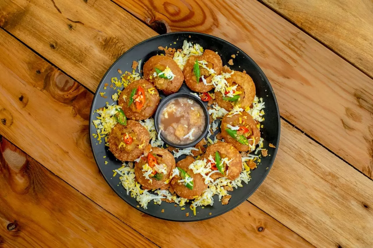 Pani puri, hollow crisp puris filled with spiced water, potato and chickpeas.