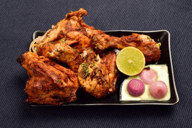 Tandoori chicken, marinated in yoghurt and spices and roasted until the edges char.