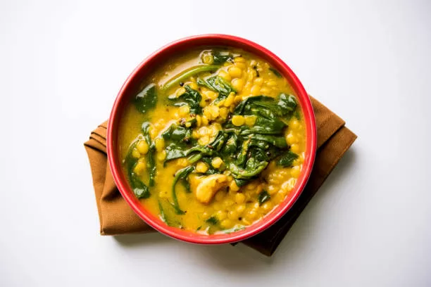 Dal palak, a lentil and spinach curry served in a karahi pan.