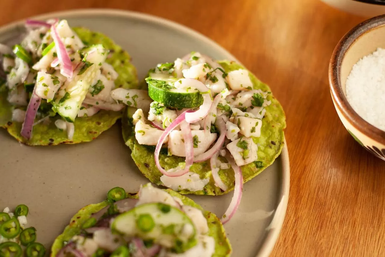 Tostadas on a flat crisp tortilla base, layered with beans, meat, lettuce and crumbled cheese.
