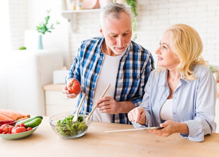 Couples preparing food with recipe as a vegan way to prevent Alzheimer's