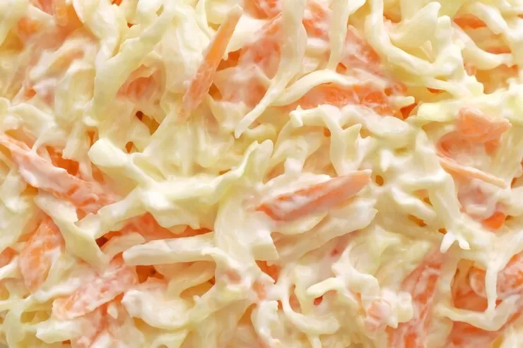 Close-up of creamy coleslaw showcasing a paleo-friendly mix of shredded cabbage and carrots in a rich dressing.