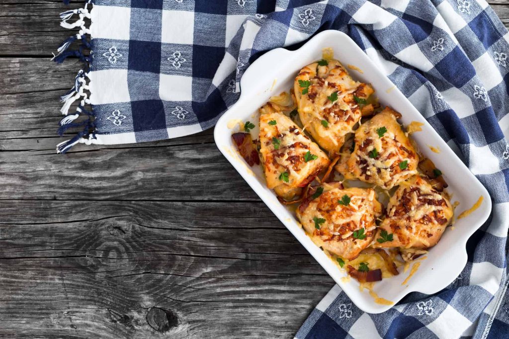 pizza stuffed chicken breast with ham, cheese, tomatoes and Provencal herbs, baked in a gratin dish, sprinkled with chopped parsley, Italian kitchen