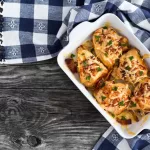 stuffed chicken breast with ham, cheese, tomatoes and Provencal herbs, baked in a gratin dish, sprinkled with chopped parsley, Italian kitchen