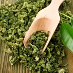 green tea leaves with wooden spoon