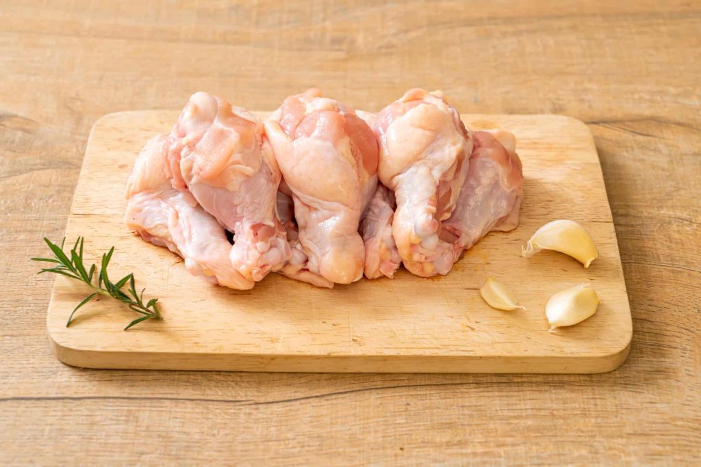 fresh raw chicken drumettes on a cutting board