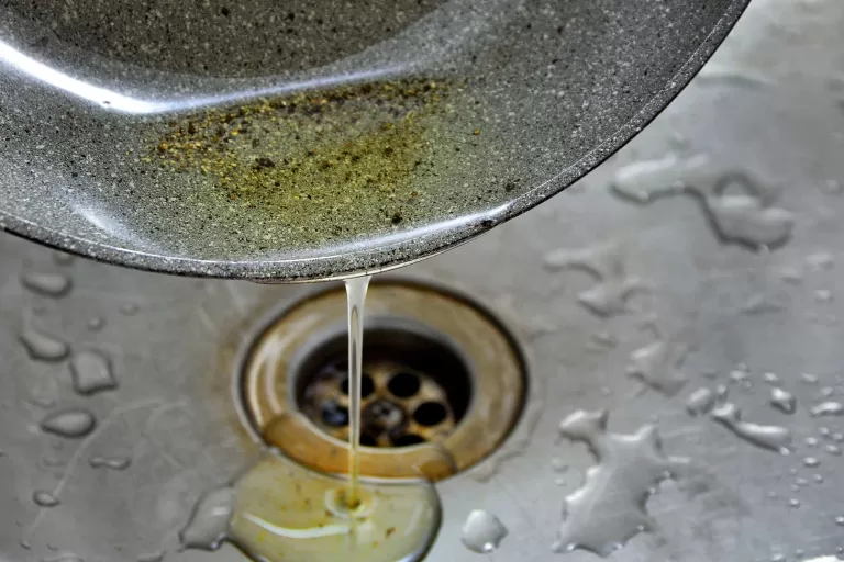 pouring_used olive oil on sink