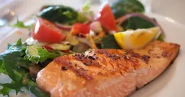 salmon with vegetables and lemon on a plate