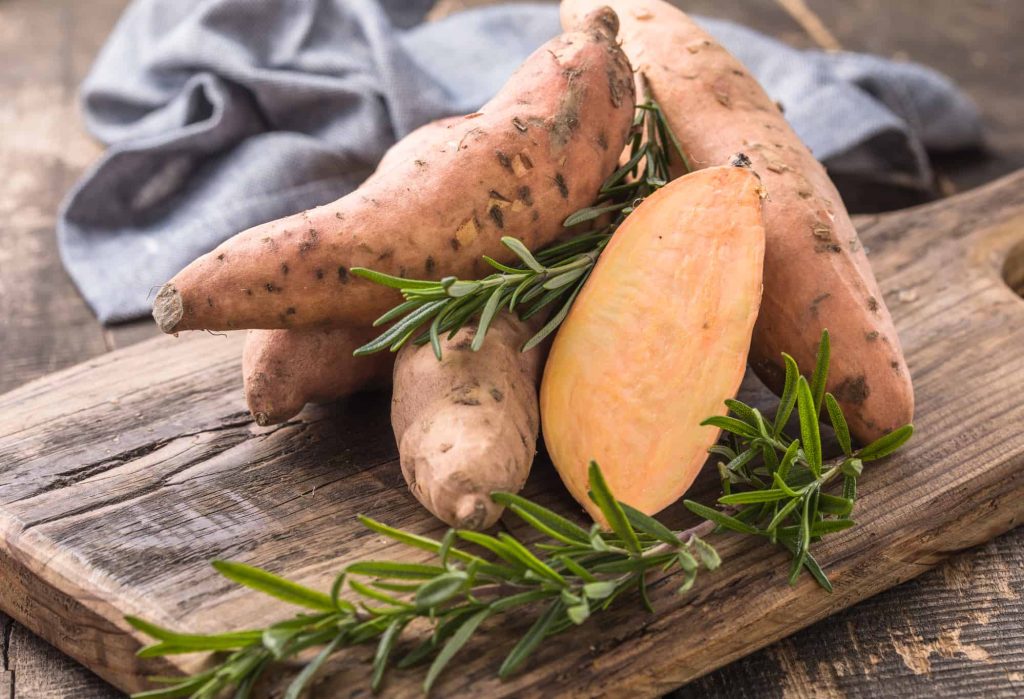 sweet potato with black spots on a cutting board