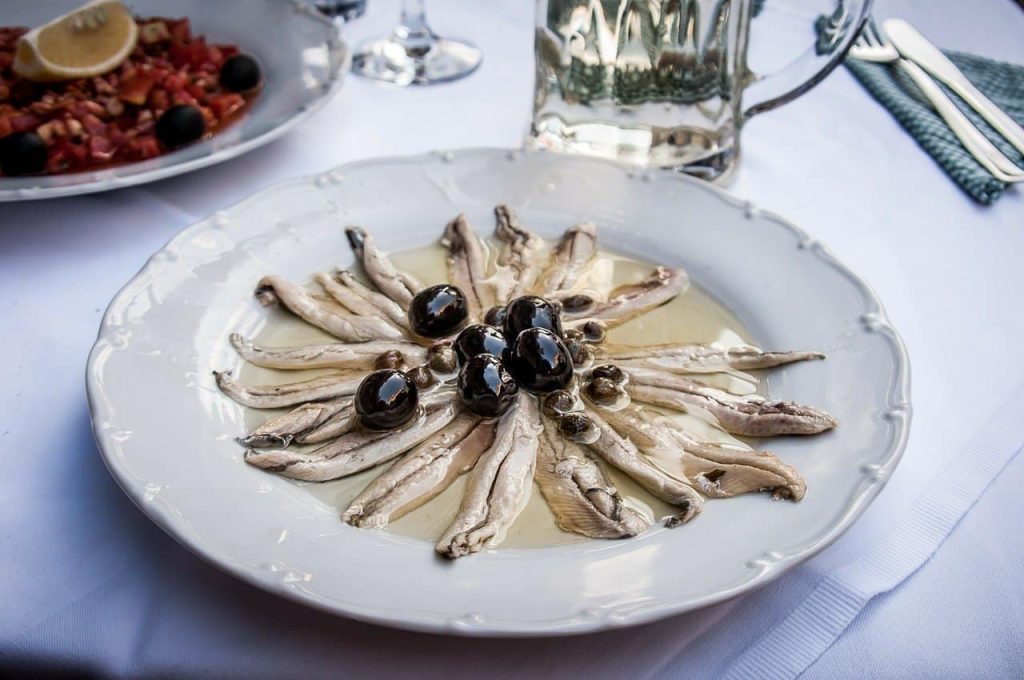 marinated anchovies on a white plate