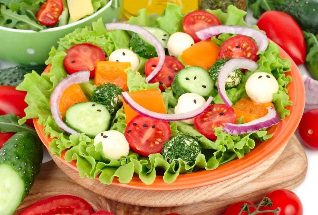 garden salad in a bowl as a side dish to fish cake