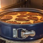 A chocolate marble cake bakes in a blue cake pan inside the oven, its swirling pattern of chocolate and yellow batter illuminated by the oven light. While similar to a pie pan, the design highlights subtle differences suitable for perfect cake creation.