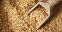 nutritional yeast flakes with wooden spoon