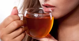 Woman with cup of fresh tasty black tea