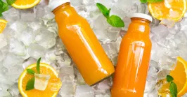 two bottles of orange juice on ice