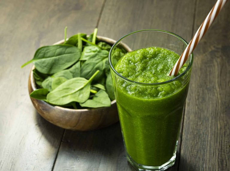 spinach smoothies in glass is on the table