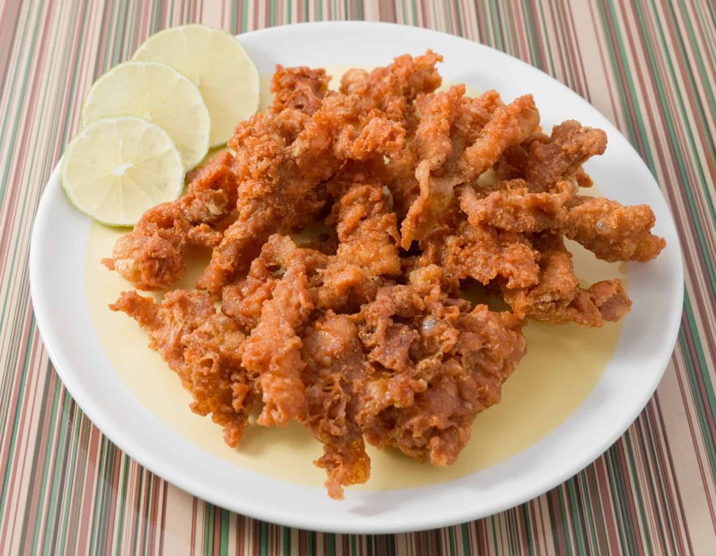 fried chicken skin with lemon slices on a plate