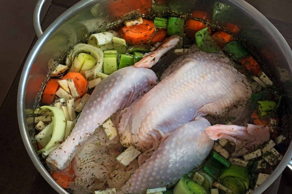 chicken broth with chicken and chicken skin in a pot