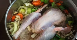 chicken broth with chicken and chicken skin in a pot