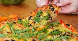 pizza with fresh toppings like arugula and olives