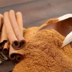 Cinnamon sticks and cinnamon powder in wooden scoop