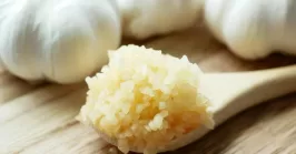 minced garlic on a wooden spoon