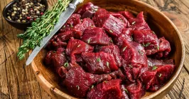 Raw venison meat on a wooden plate