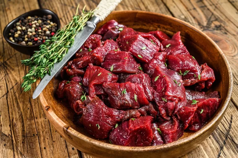 Raw venison meat on a wooden plate