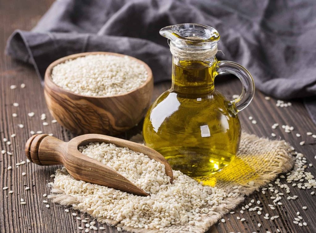 Sesame oil in glass  and seeds