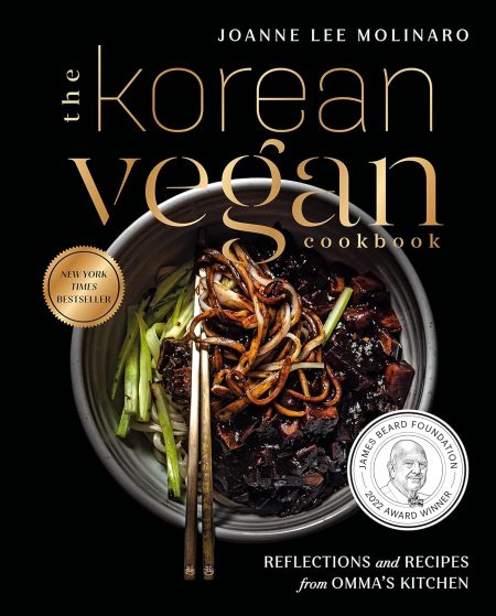 Cover of "The Korean Vegan Cookbook: Reflections and Recipes from Omma's Kitchen" by Joanne Lee Molinaro. Displays a bowl of noodles with vegetables and chopsticks, evoking the essence of Omma's Kitchen. Boasts a James Beard Foundation Award Winner badge and emphasizes its status as a New York Times bestseller with delectable recipes included.