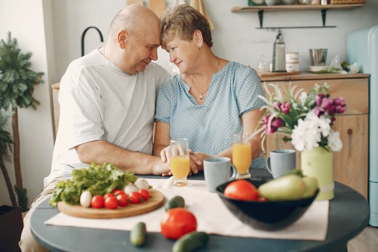 Couple preparing food in the kitchen as part of a vegan way to prevent Alzheimer's