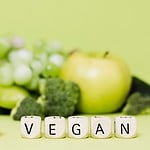 A vibrant plate of fresh fruits and vegetables promoting a healthy vegan lifestyle. Emphasizing the benefits of going vegan.