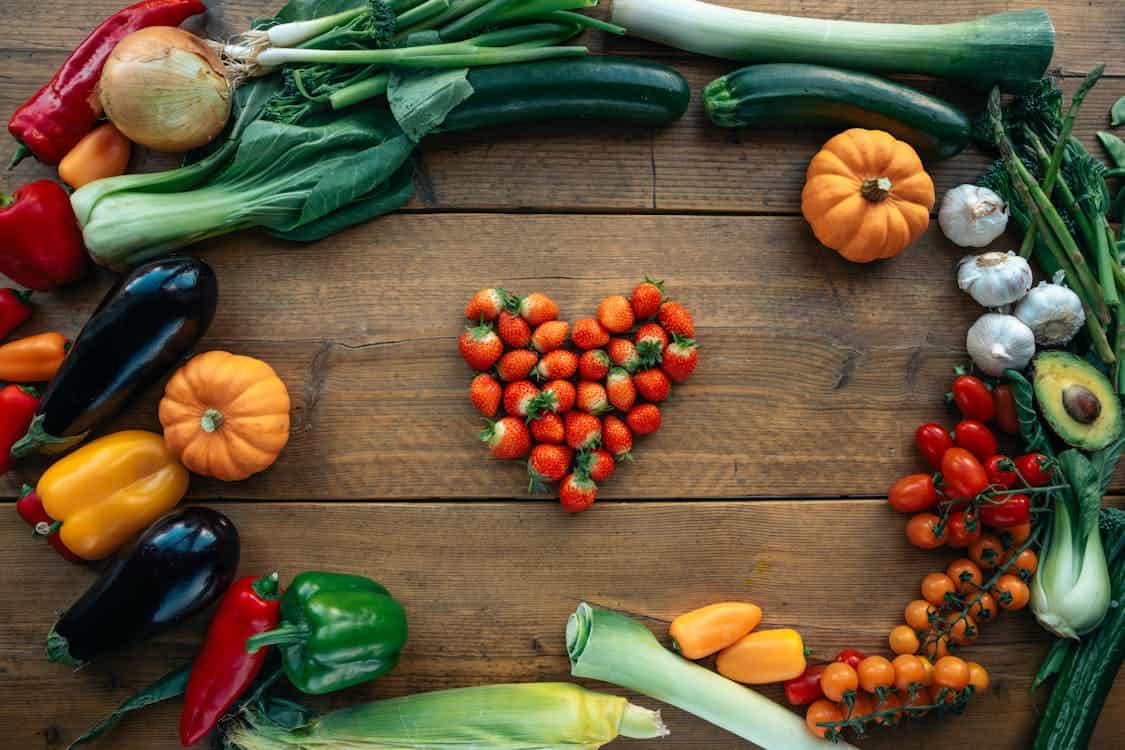 A close-up shot of various vibrant chili peppers in red, green, and yellow, arranged together. The bright colors and fresh appearance emphasize their ripeness and diversity in veggie gardening.