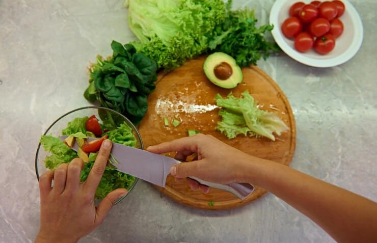 A close-up of someone preparing vegetables on a cutting board, emphasizing nutritious choices for managing eczema.