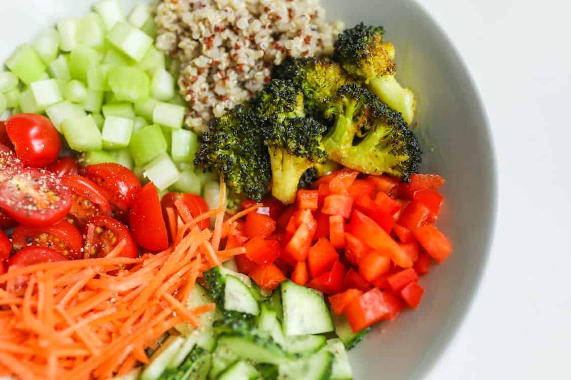 A colorful bowl filled with fresh broccoli, carrots, and assorted vegetables. The vibrant mix showcases healthy eating.