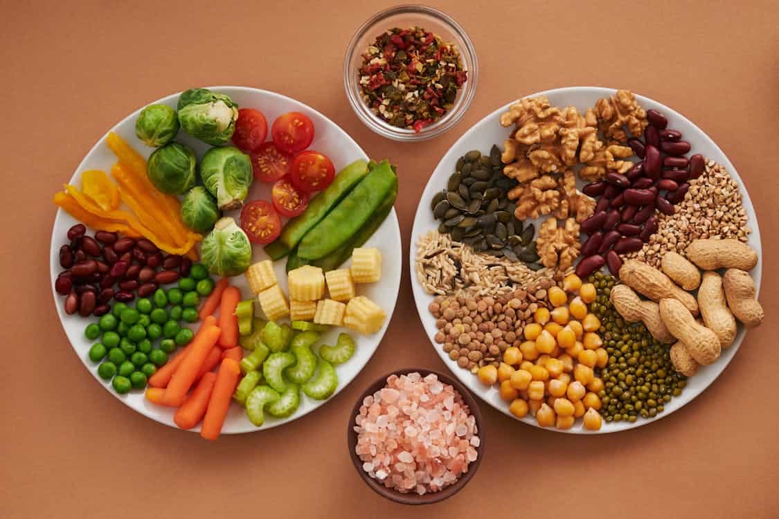 A colorful plate featuring a variety of fresh vegetables, promoting a vegan diet for optimal digestive health.