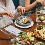 A diverse group of individuals enjoying a vegan meal together at a table, promoting a healthy digestive system.
