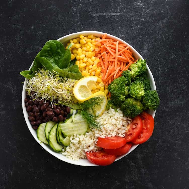 A vibrant bowl filled with assorted colorful vegetables and fluffy rice. The dish showcases a healthy and appetizing meal.