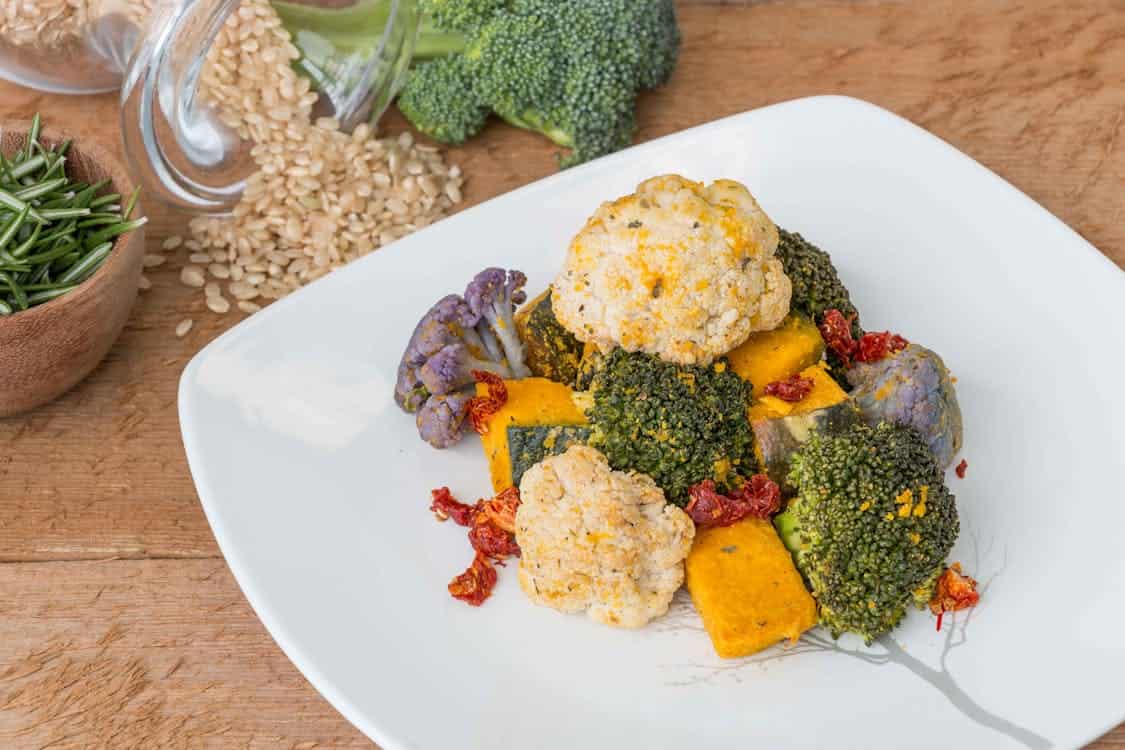 A vibrant plate featuring broccoli, cauliflower, and assorted vegetables, promoting a vegan diet for digestive health.