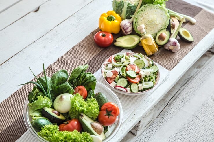 An inviting spread of fresh vegetables and fruits on a wooden table, emphasizing the benefits of a vegan diet for eczema management.